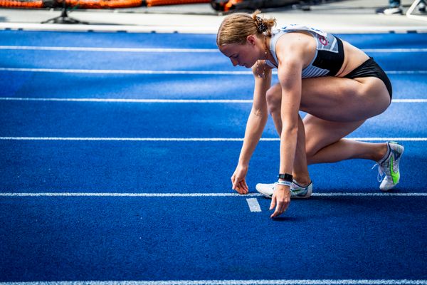 Eine Staffellaeuferin markiert den Anlaufpunkt waehrend der deutschen Leichtathletik-Meisterschaften im Olympiastadion am 26.06.2022 in Berlin